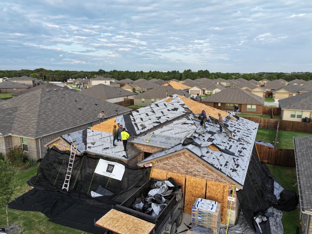 Workers installing a new roof on a residential home in a suburban neighborhood.